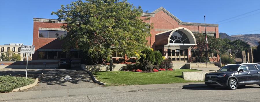 The detachment seen from the street, with mature trees and lawn.